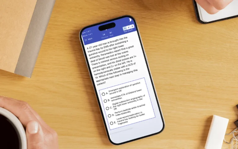 Phone on a desk showing a QLearn surgery question with answer choices