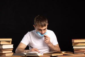 Medical student surrounded by books, writing his personal statement for residency.